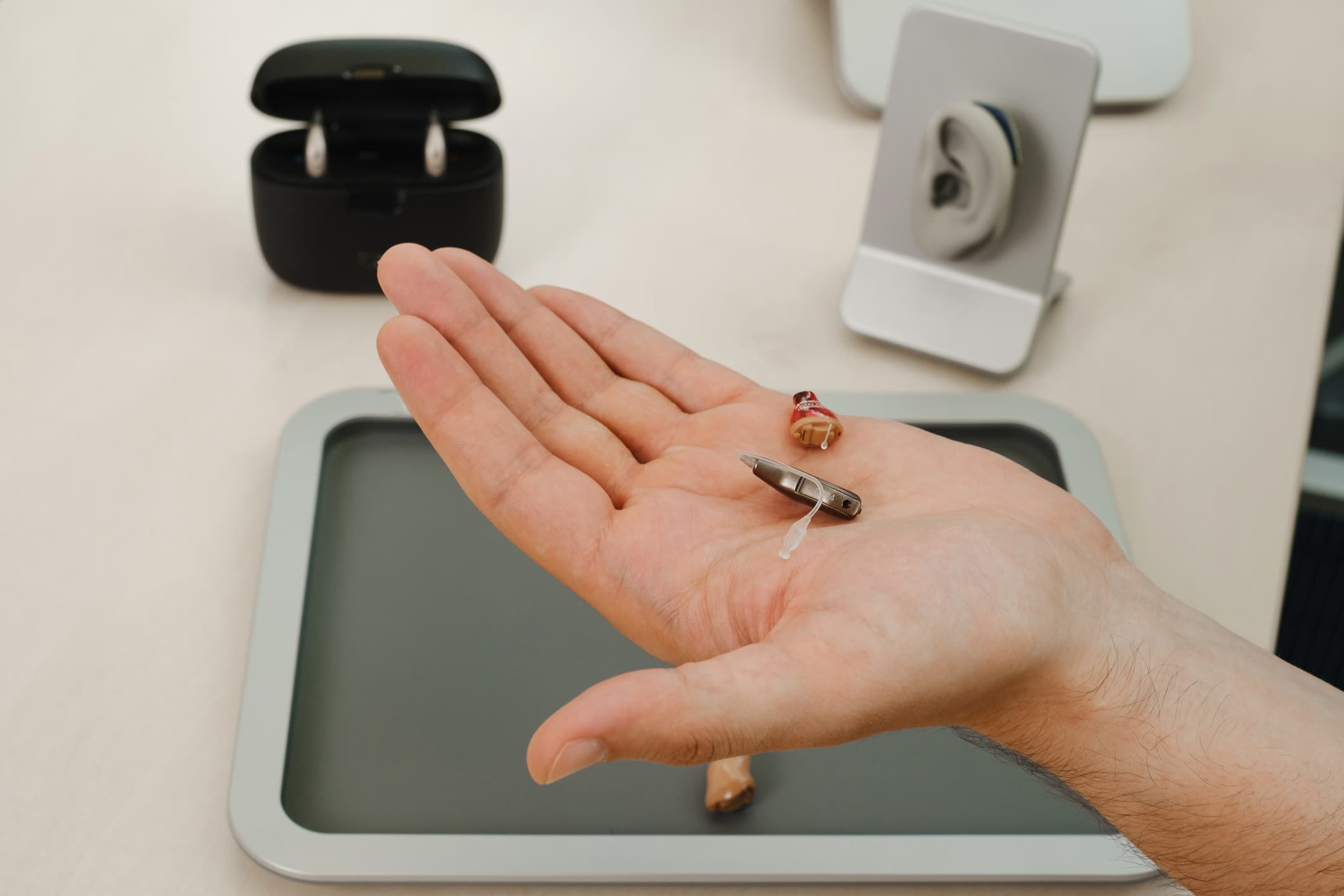 Hearing aids in hand at Prairie Hearing Centre