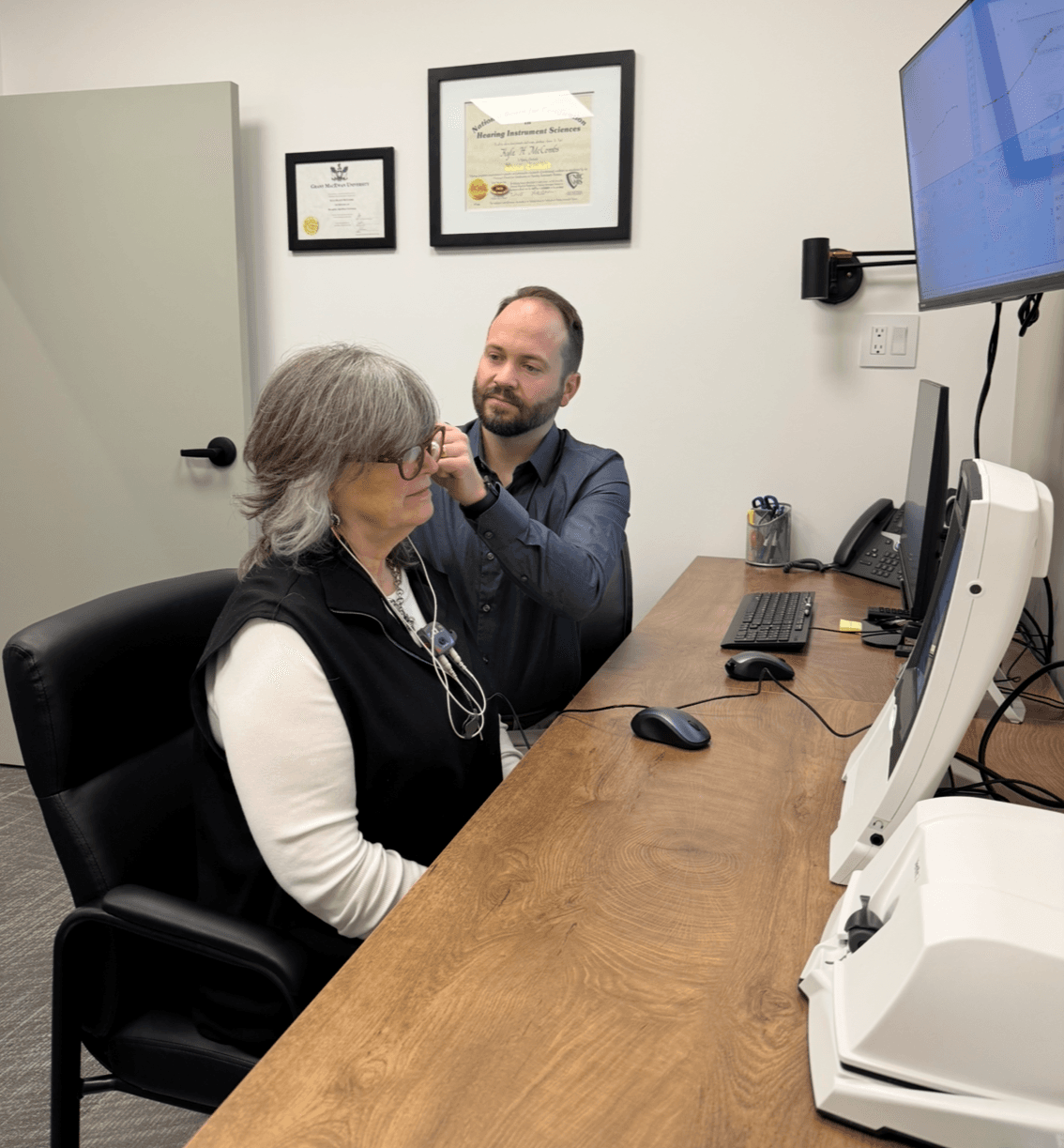 Prairie Hearing specialist checking ears during an assessment